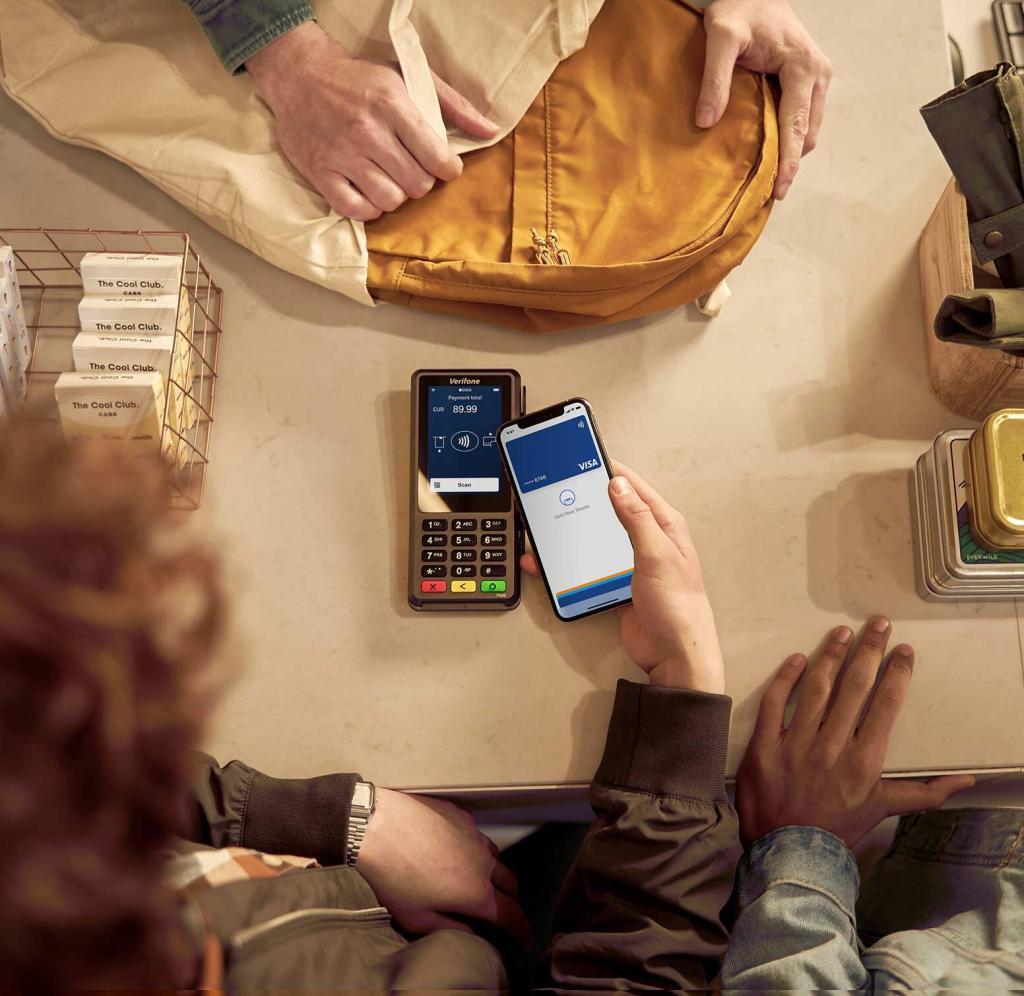 Ein Handy wird zum Bezahlen an das Kartenlesegerät gehalten.